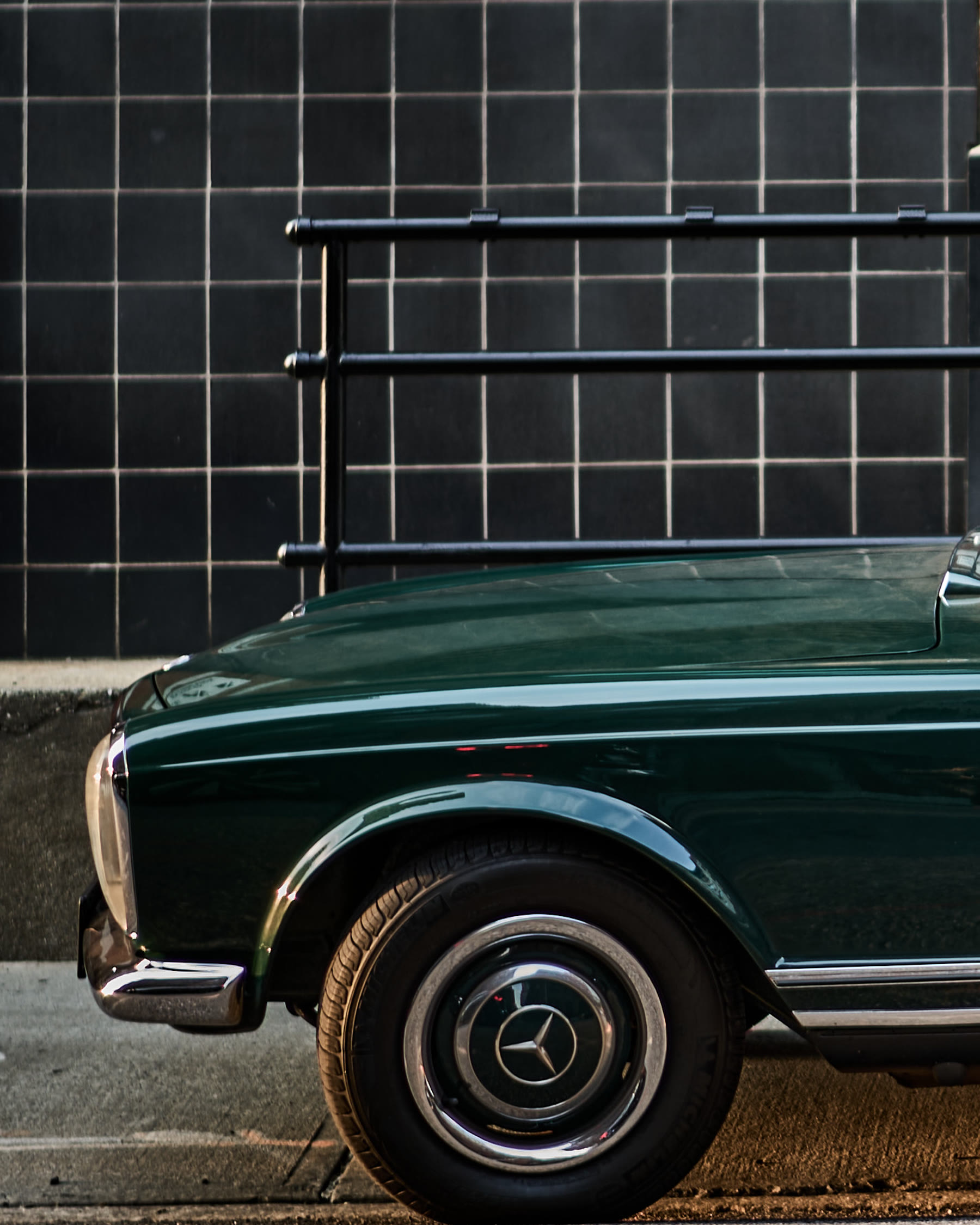 The vintage green Mercedes parked against a tiled New York wall