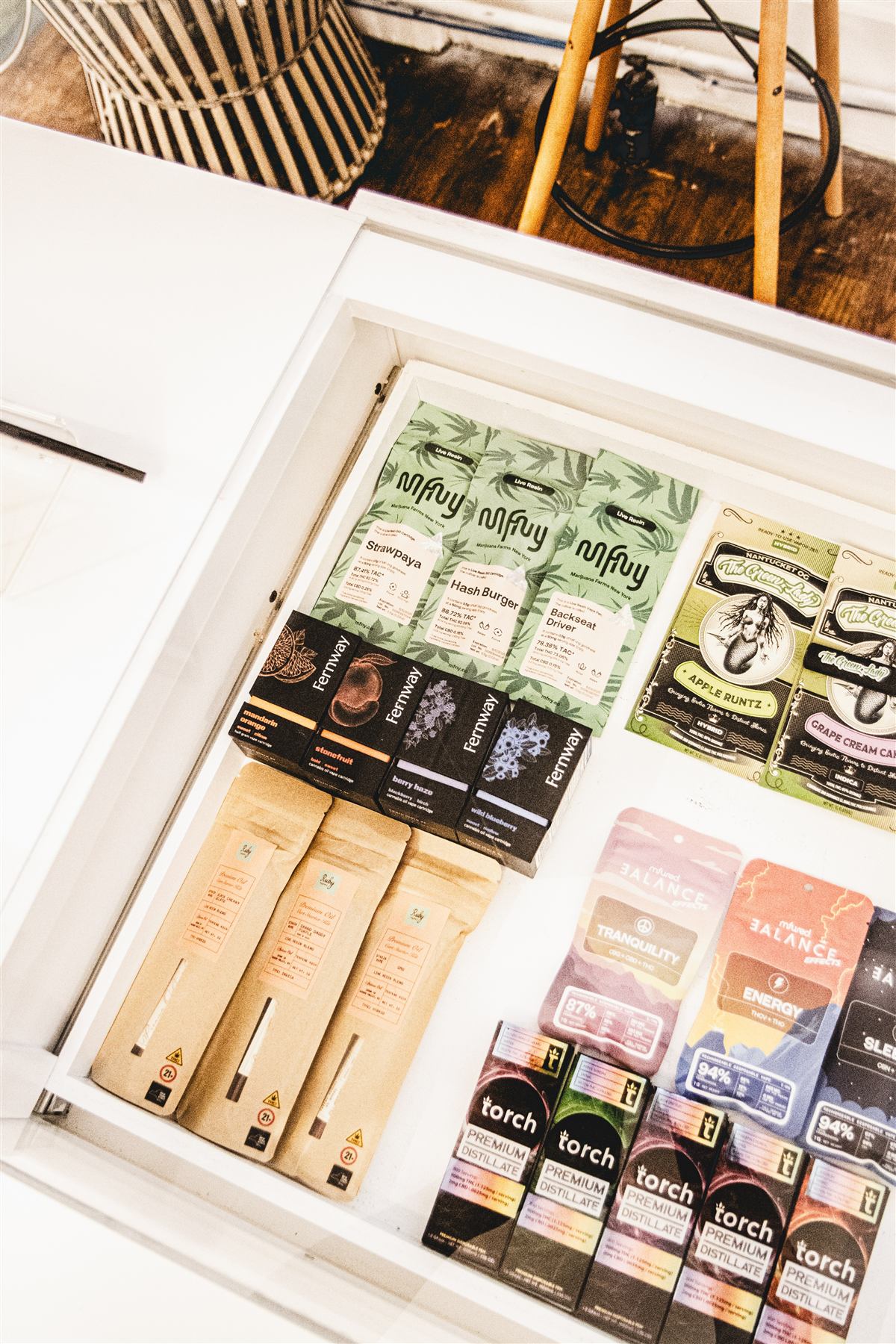 A dark display drawer of curated vape hardware and cartridges inside the store at 122 East 25th Street